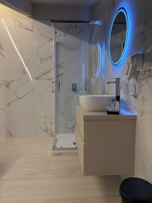 A modern bathroom with a glass-enclosed shower, a vanity with a sink, and a mirror with LED lighting. - B&B Molly (Napoli)