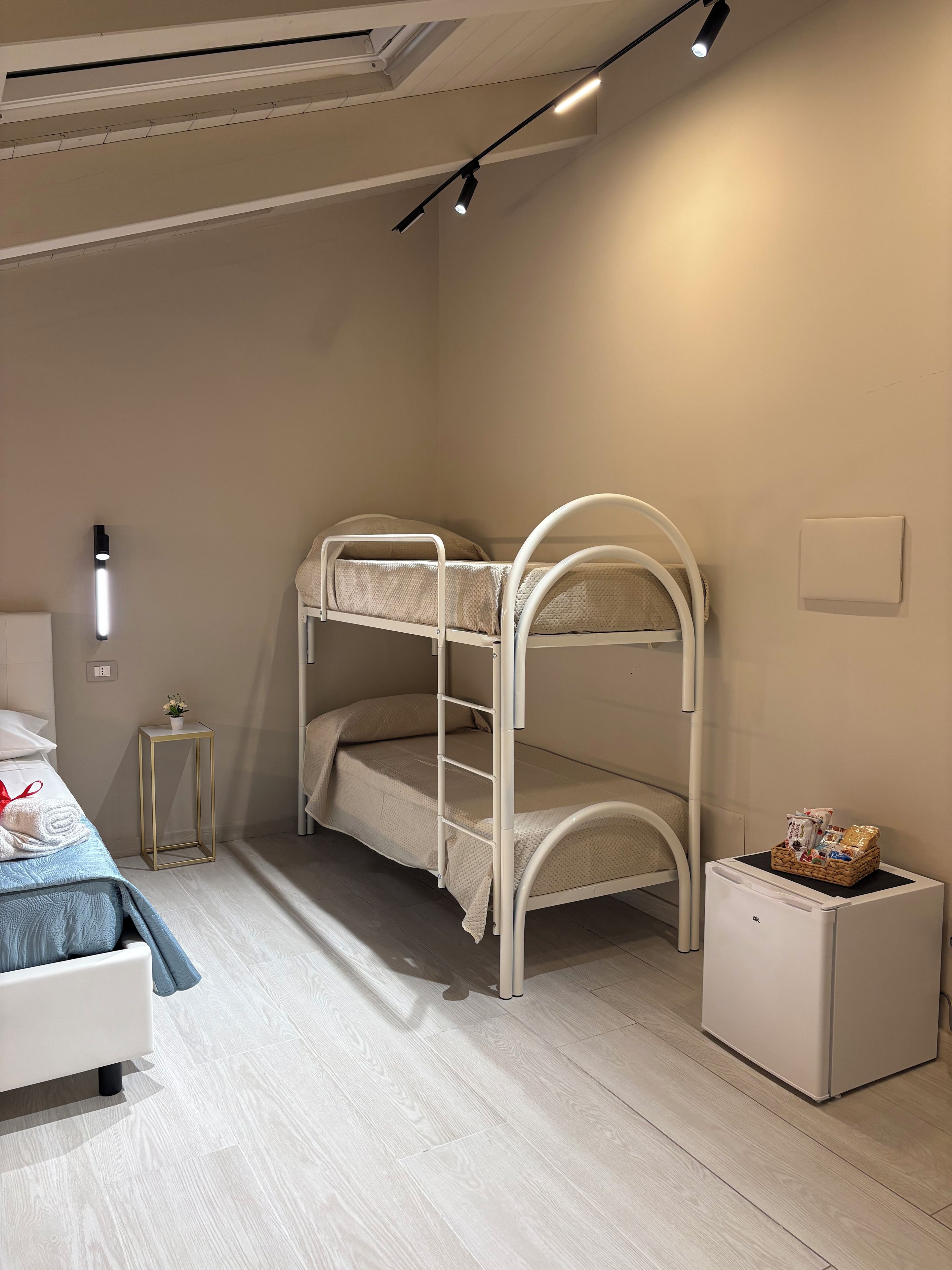 Ein Etagenbett mit einem kleinen Nachttisch und einem weißen Schrank.