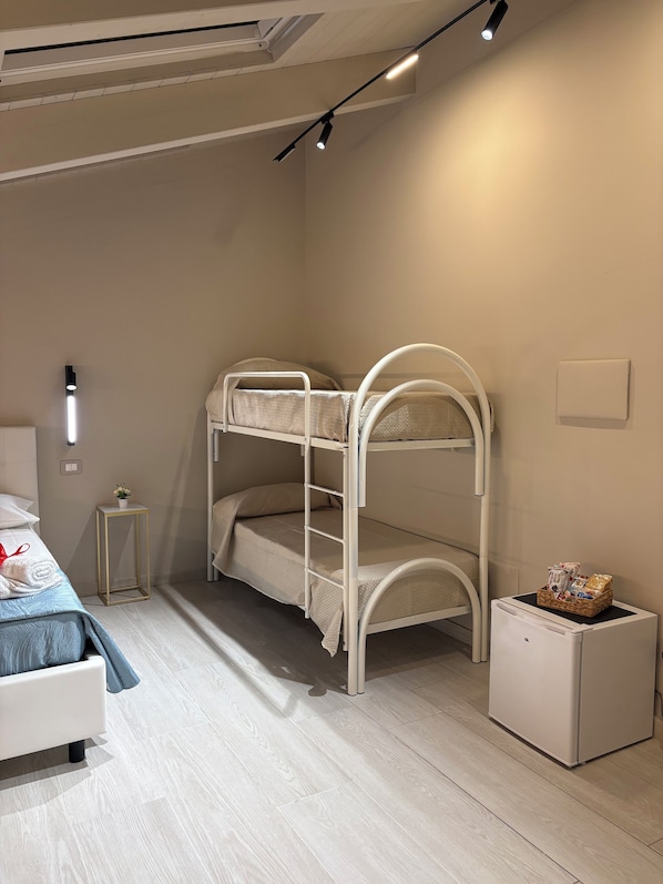 A bunk bed with a small bedside table and a white cabinet. - B&B Molly (Napoli)