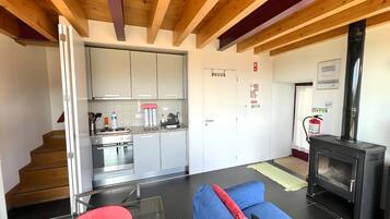 Una sala de estar moderna con una mesa de centro de vidrio, un sofá y una chimenea.