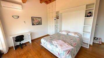 Un dormitorio con cama, escritorio y armario.