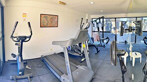 Ein Fitnessstudio mit Laufbändern, Crosstrainern und Gewichtsmaschinen.