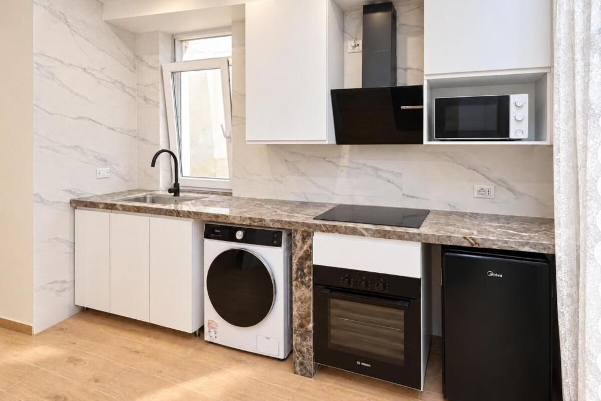 Una cocina moderna con lavadora, lavavajillas, horno y microondas integrados.