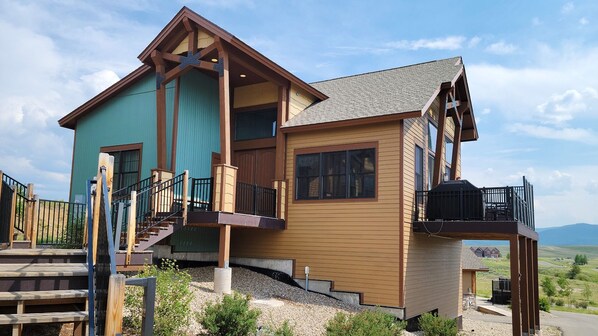 A two-story house with a balcony and a staircase leading to the upper level. - WorldMark Rocky Mountain Preserve - 2BR Twin Suite with Fireplace at 8,000 Ft (Granby)