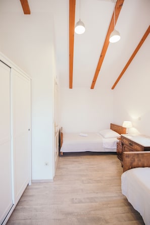 A bedroom with a bed, bedside table, lamp, and a wooden headboard. - Charming stonehouse Ramiro (Podašpilje)