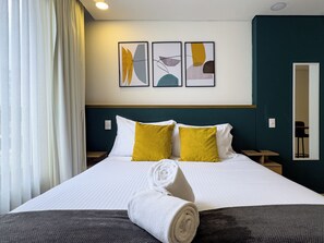 A hotel room with a bed, a rolled towel, and artwork on the wall. - Wonderful 2BR Apt in Usaquen (Bogotá)