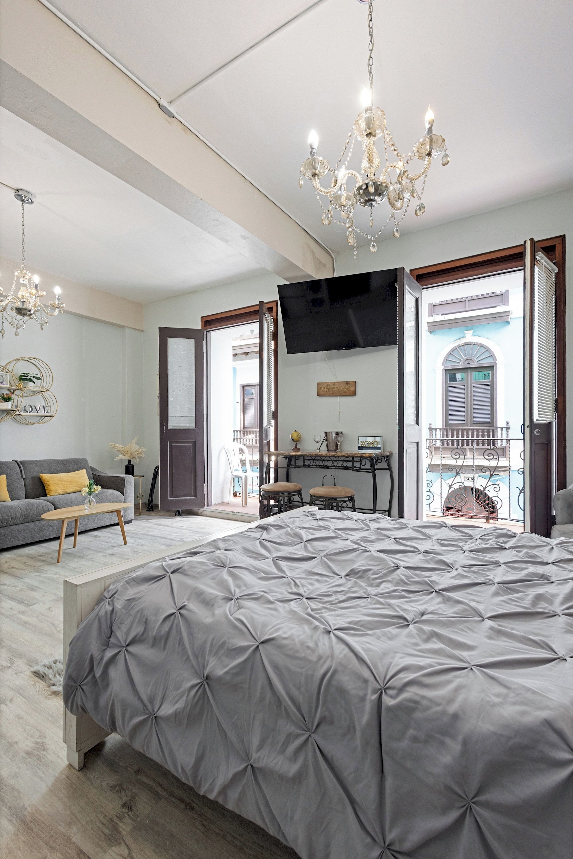 Un dormitorio con una cama grande, un televisor en la pared y un balcón con vistas.