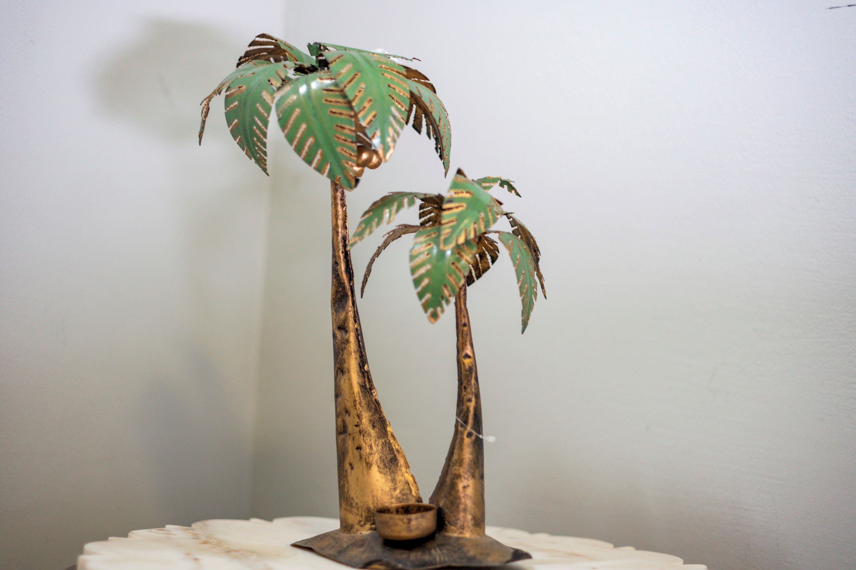 A decorative plant with two trunks and a small pot at the base.