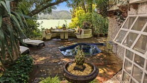 Une terrasse avec mobilier d’extérieur, une piscine et une vue sur un lac.
