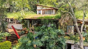 A house with a green roof, surrounded by dense vegetation and a red staircase. - Villa Oasis del Cielo · Vista al Lago y Montaña (Valle de Bravo)