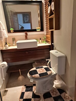 Ein kleines Badezimmer mit Toilette, Waschbecken und Spiegel.