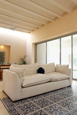A modern living room with a beige sofa, a patterned rug, and a large window. - Casa Kaban - Centro - C Gastronomico y La Plancha (Centro)