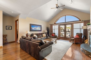 A spacious living room with a high ceiling, a large window, and a fireplace. - This is a test property. Do not book this! (Pattison)