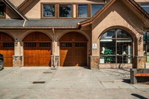 A building with two wooden garage doors, a stone facade, and a large arched window. - This is a test property. Do not book this! (Pattison)