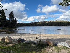 Ein See mit einem Steg, umgeben von Bäumen und Felsen.