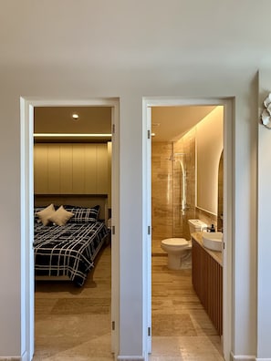 Une chambre à coucher avec un lit et une salle de bain avec douche et toilettes.