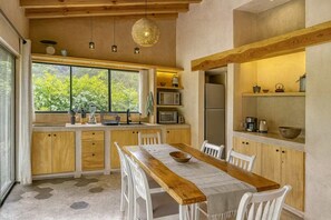 Una cocina moderna con armarios de madera, una mesa de comedor y un ventanal amplio.