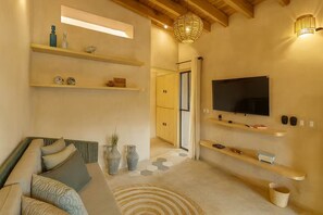 Ein modernes Wohnzimmer mit einer Couch, einem Fernseher und dekorativen Regalen.