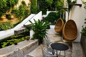A patio with a small pool, wicker chairs, a table, and a staircase leading to a higher level. - AVA19 Adults Only Villa (Puerto Vallarta)