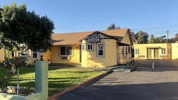 A yellow building with a sign that reads 'OFFICE OPEN' on the front.