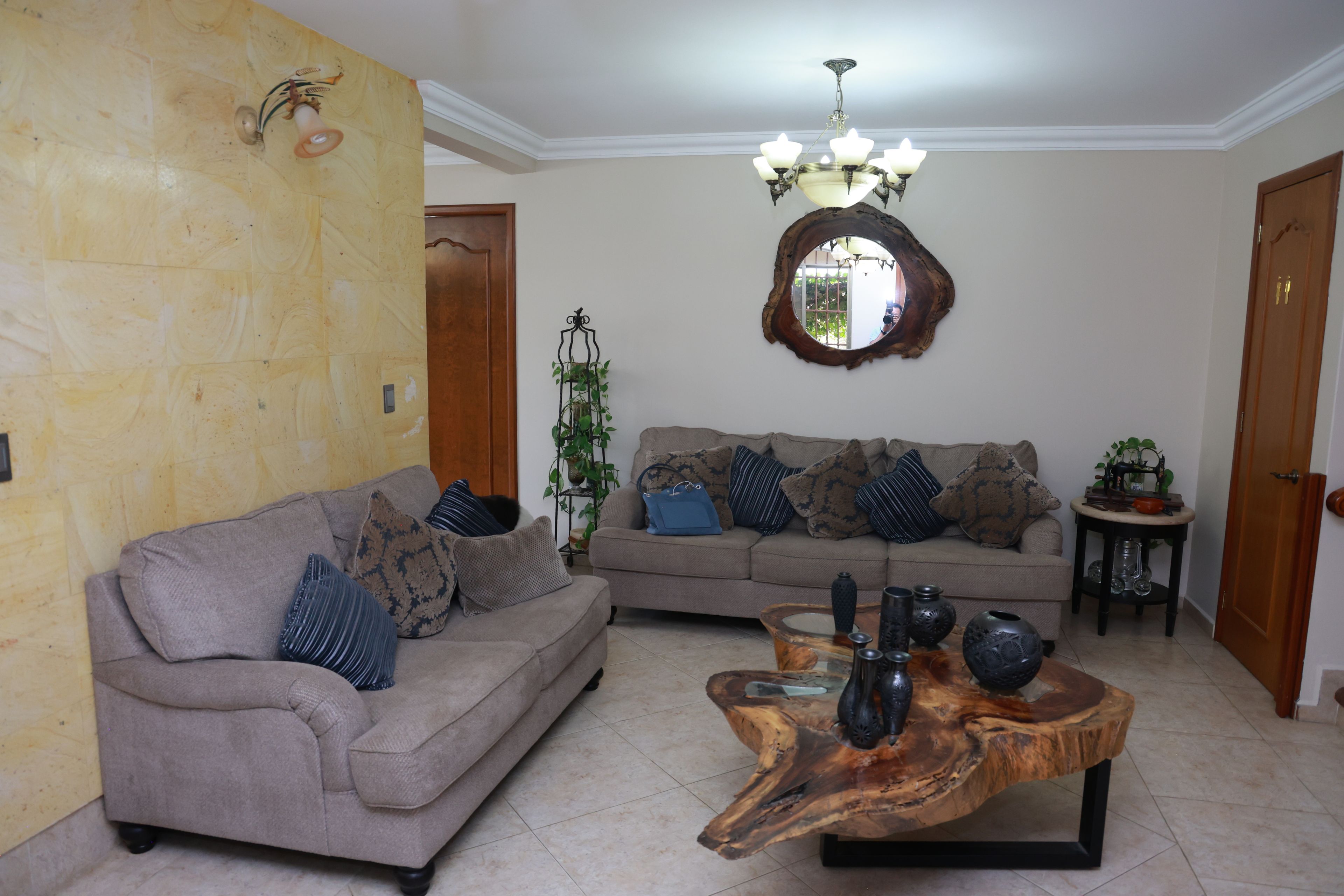 A living room with a sofa, a coffee table, and a mirror on the wall.