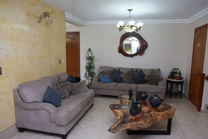 A living room with a sofa, a coffee table, and a mirror on the wall.