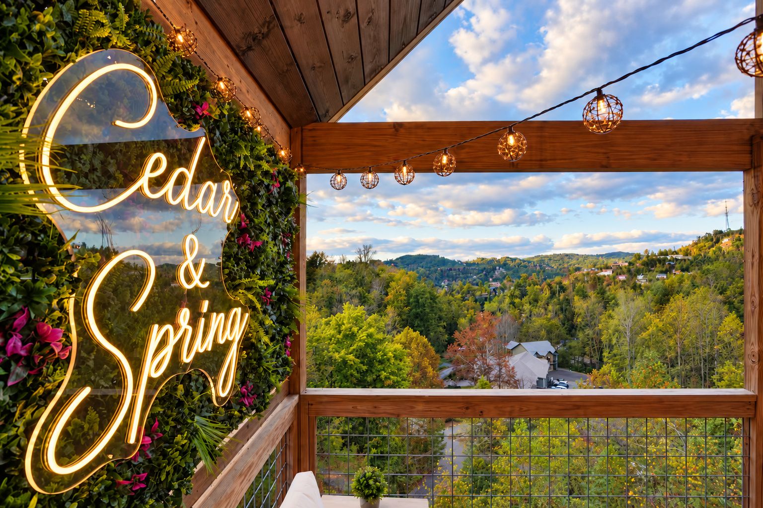 A wooden balcony with a neon sign reading 'Cedar & Spring' and a view of a forested landscape.