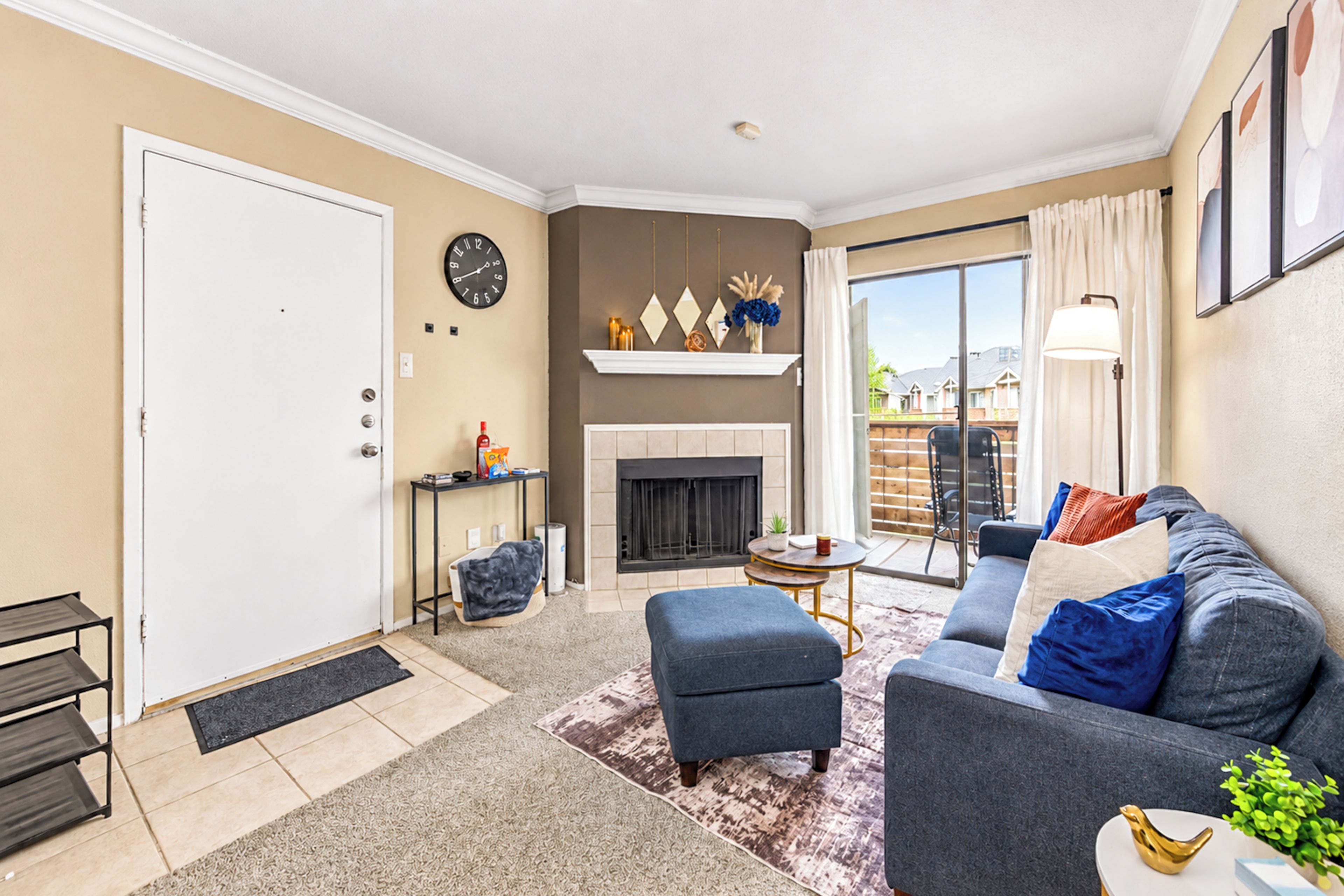 A living room with a fireplace, a sofa, a coffee table, and a door.