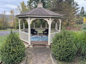 A gazebo with a tiled roof, two chairs, and a table. - Paddle Point Retreat - Mountain & Lake Views - Fire Pit (McHenry)