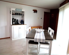 A dining area with a table set for two, a coffee station with various coffee makers, and a sign indicating the room as 'LAKE HOUSE'. - Paddle Point Retreat - Mountain & Lake Views - Fire Pit (McHenry)
