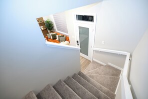 A staircase with carpeted steps leading to a landing. - Hebron Place | Elegant 3-Bedroom Stay for 6 (Regina)