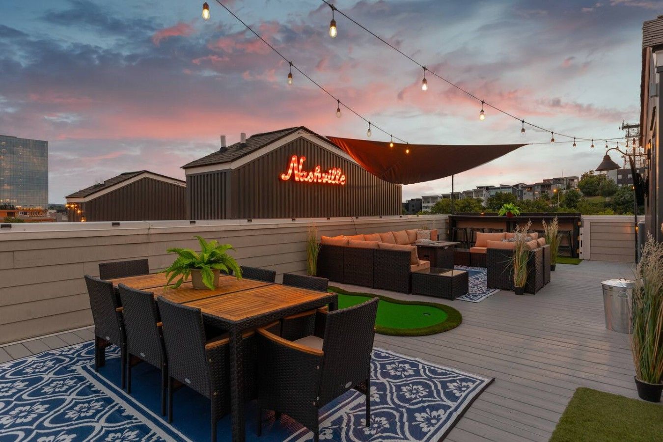 An outdoor patio with a dining area, seating, and a neon sign.