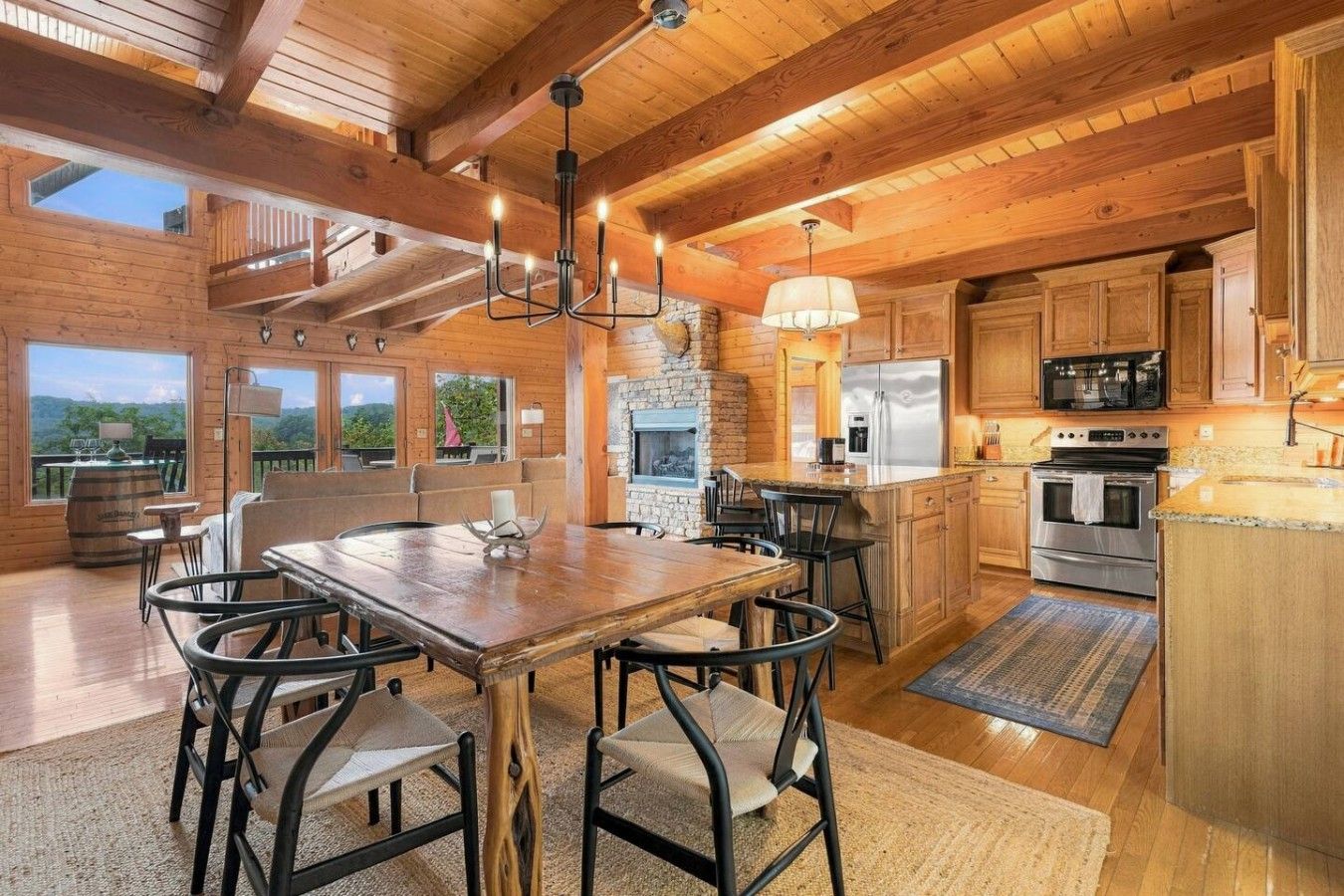 Een ruime keuken met houten balken, een stenen openhaard en moderne apparatuur.