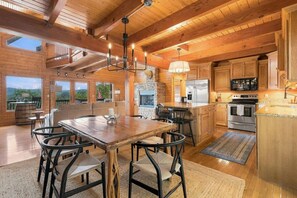A spacious kitchen with wooden beams, a stone fireplace, and modern appliances. - Lake Views with Hot Tub, Large Deck, Gym, Ping Pong (Smithville)