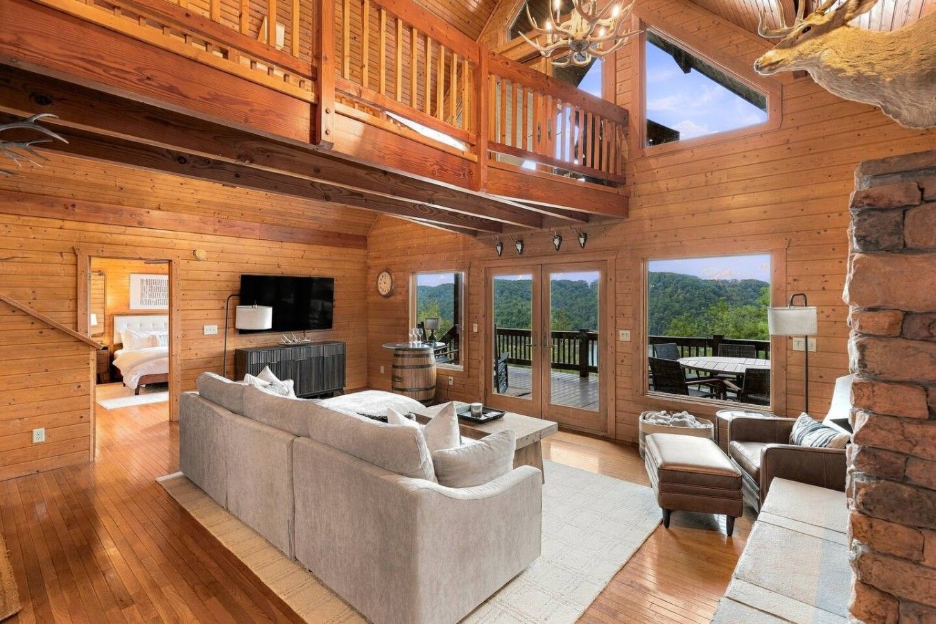 A spacious cabin interior with a large sofa, a dining area, and a fireplace.