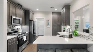 Large kitchen with stainless steel appliances. Fully equipped with everything you need for your stay! Coffee machine + coffee is provided. Kitchen island provides seating for 3.