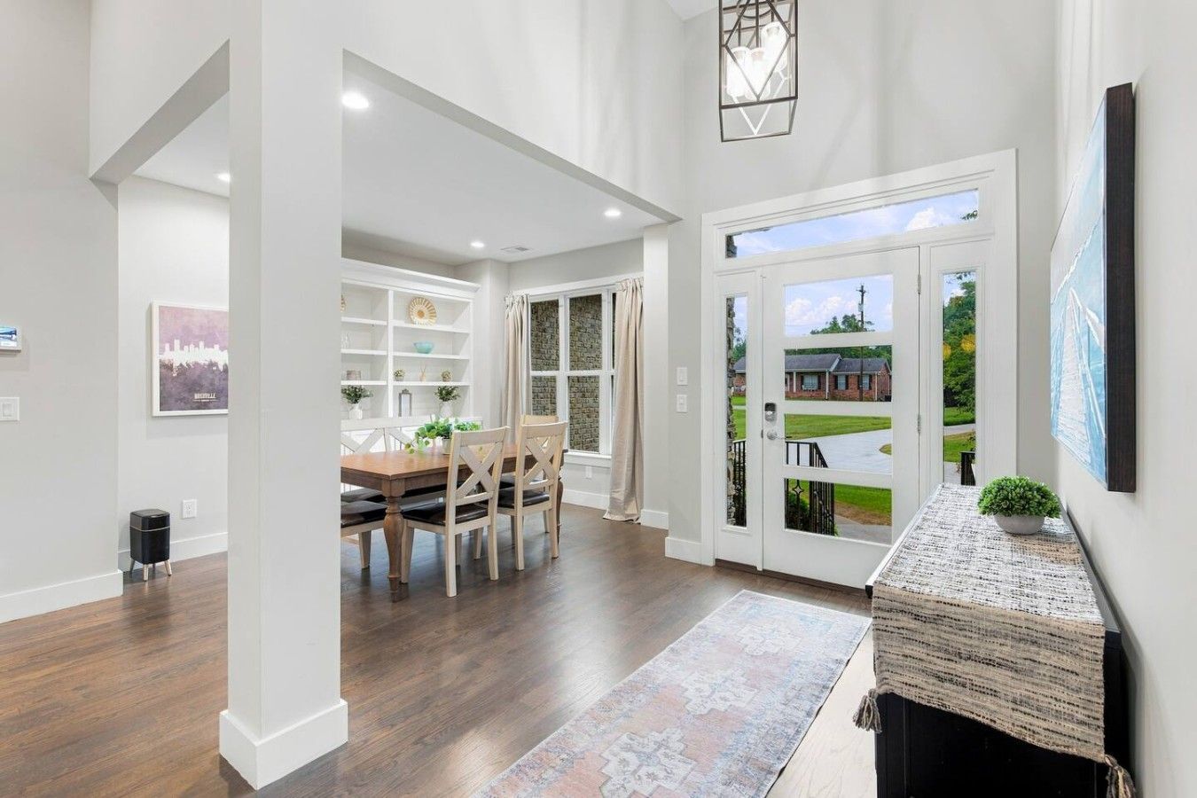 A spacious hallway with a dining area, a fireplace, and a view of the outside.