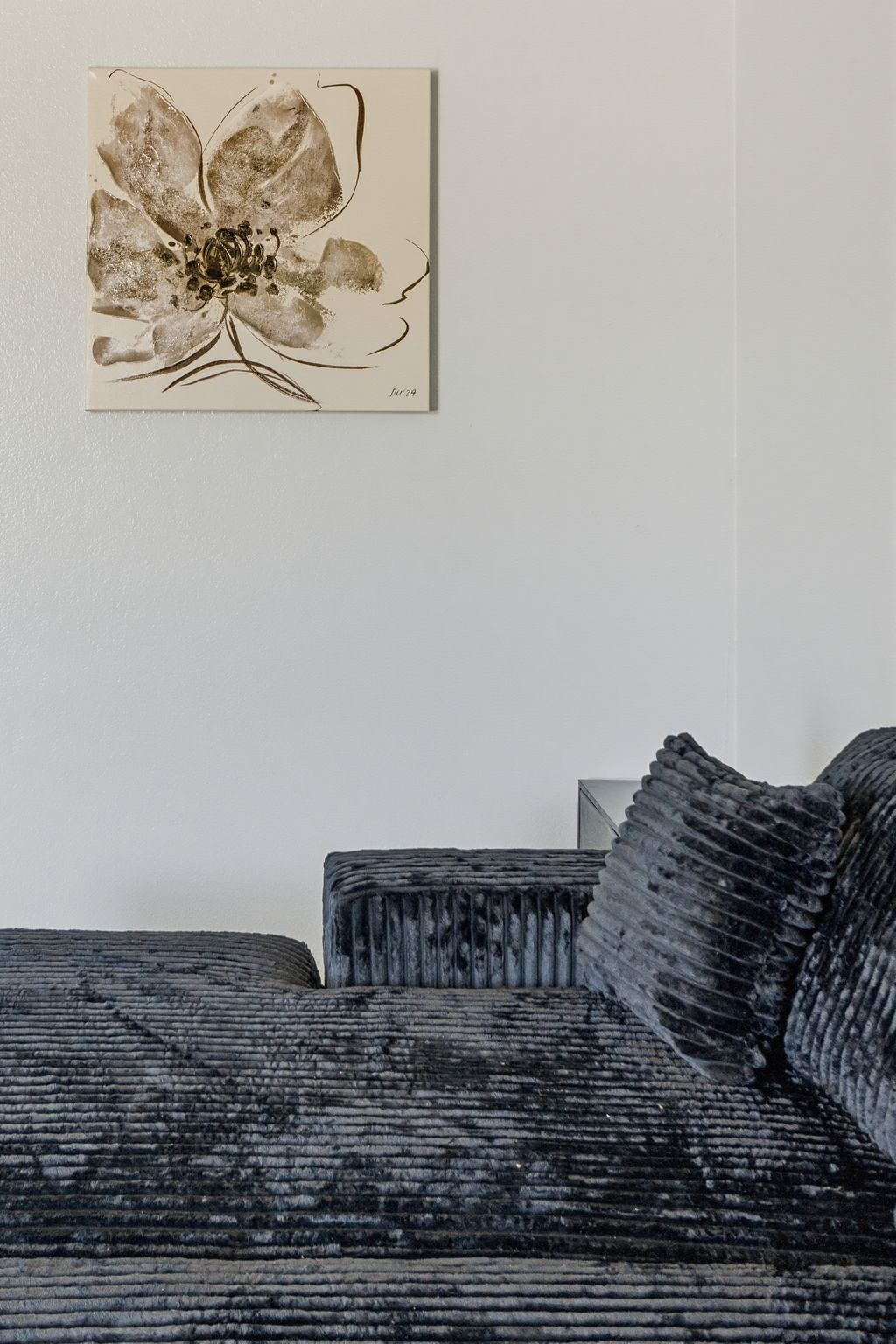 A room with a sofa and a wall-mounted artwork.