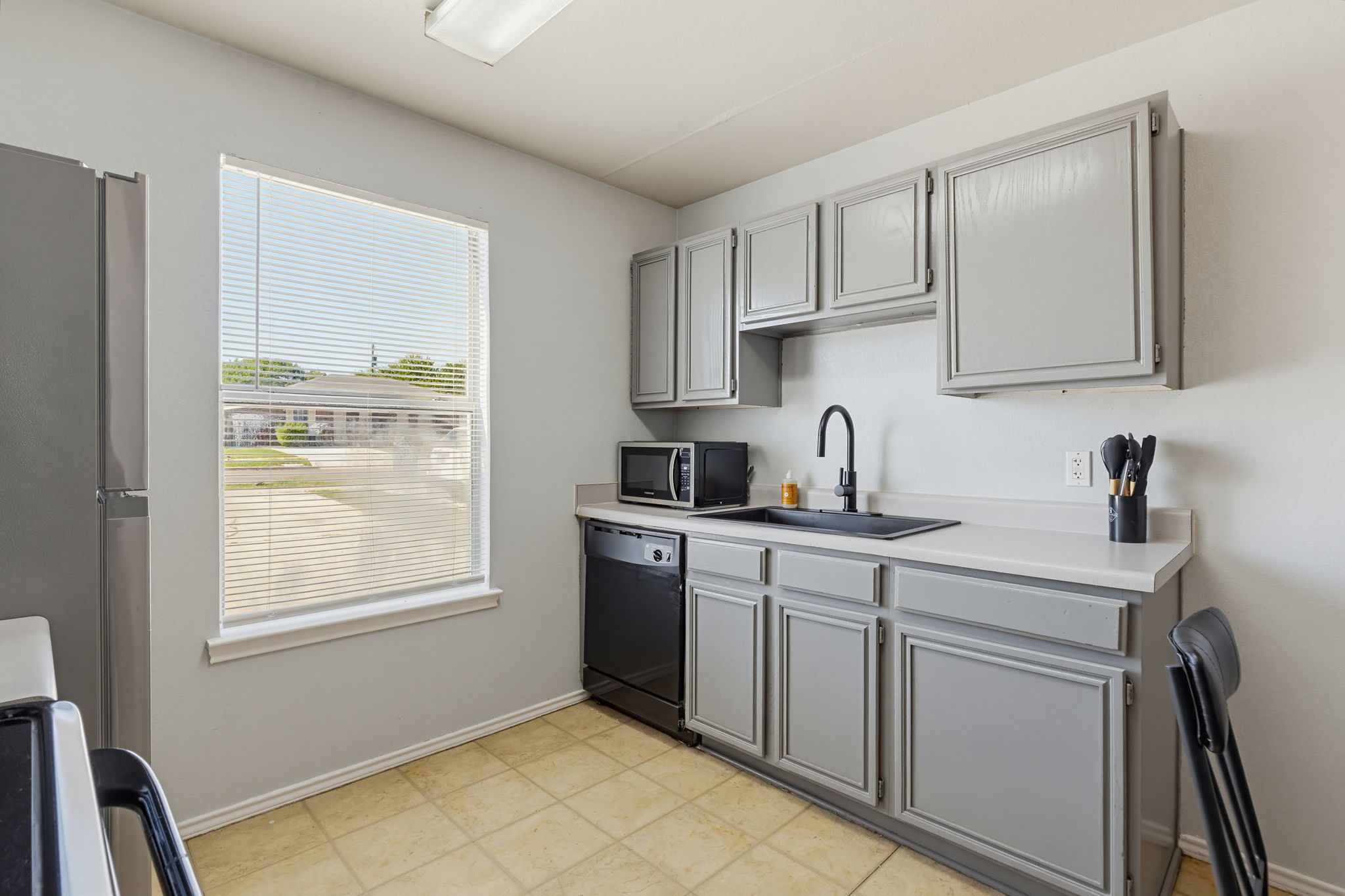 A compact kitchen with a dishwasher, a microwave, and a sink.