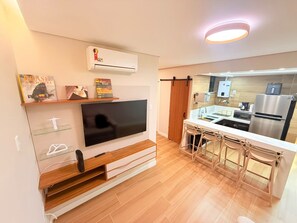 Eine moderne Küche mit Einbauherd, Kühlschrank und Essbereich mit Barhocker.