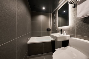 A modern bathroom with a bathtub, a sink, and a toilet. - Cave Ryokan Hotel by Anook Gangbuk Suyu (Seoul)