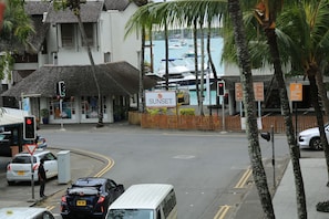 Vista de la calle con un edificio identificado como 'SUNSET' y un cartel para 'Grand Cay Store'.