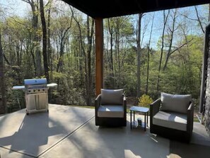 An outdoor patio with a grill, two sofas, and a small table. - Nature's Retreat on Lake Norman (Mooresville)