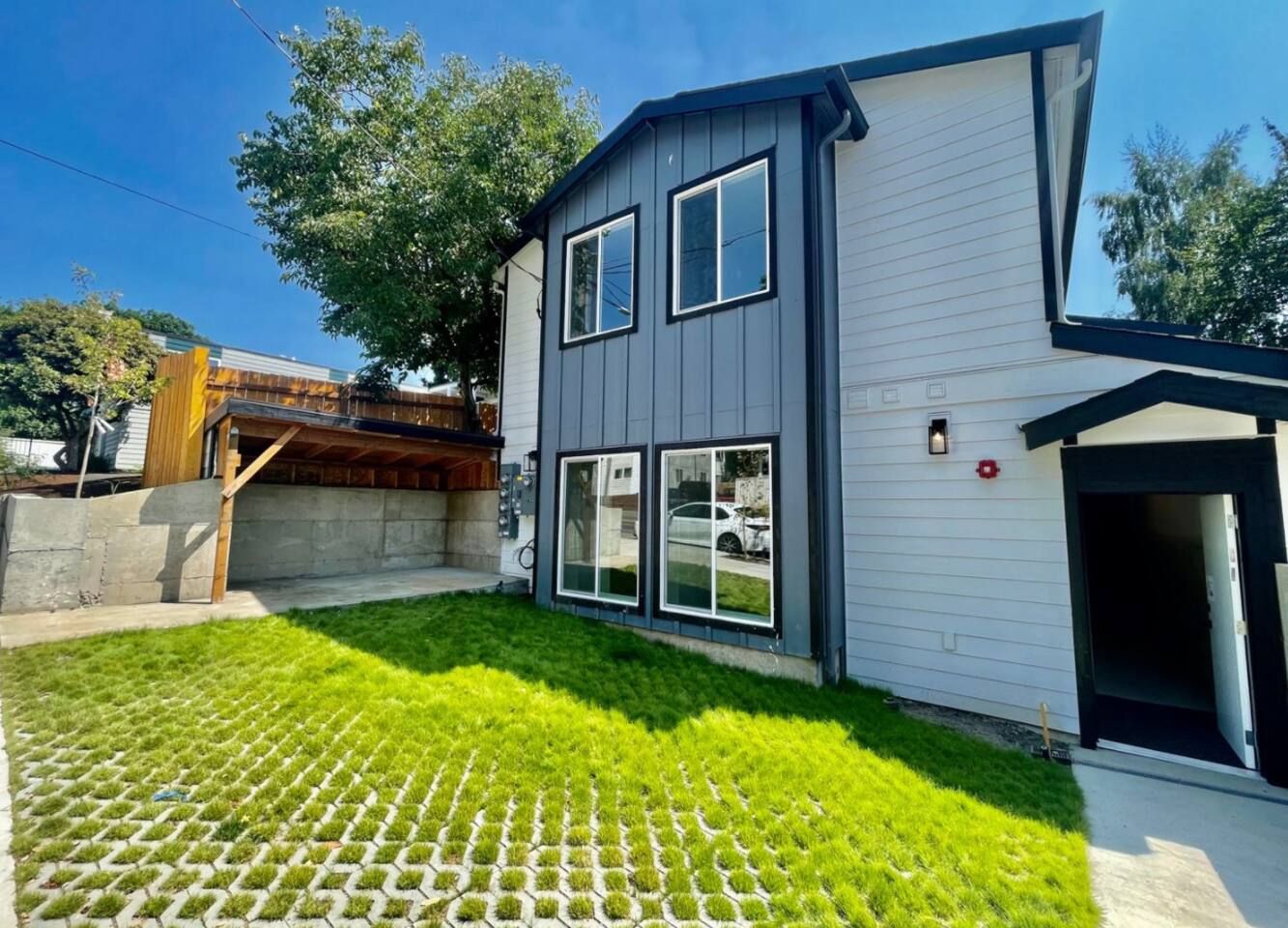 A modern two-story house with a well-maintained lawn and a visible garage door.