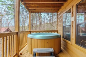 Una terraza de madera con un jacuzzi y un banco.