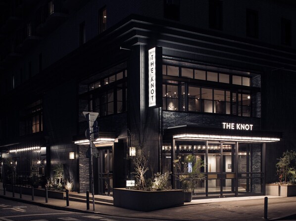 A modern hotel facade with illuminated signage, large windows, and a well-lit entrance. - THE KNOT YOKOHAMA (Minamisaiwai, Nishi-ku, Yokohama-shi,)