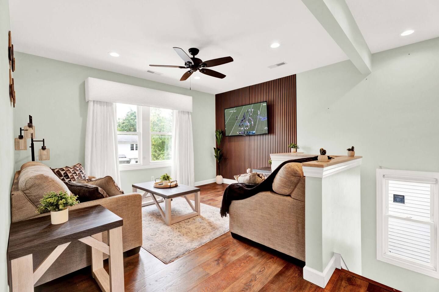 A modern living room with a sofa, coffee table, and a television mounted on the wall.