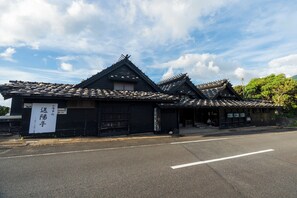 Perinteinen japanilainen rakennus, jossa on tiilikatto ja kyltti.