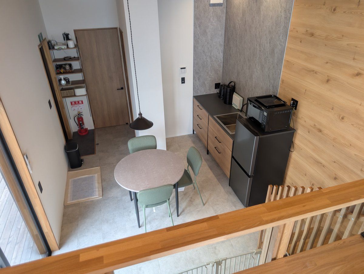 Una cocina compacta con comedor, un refrigerador y un armario de madera.