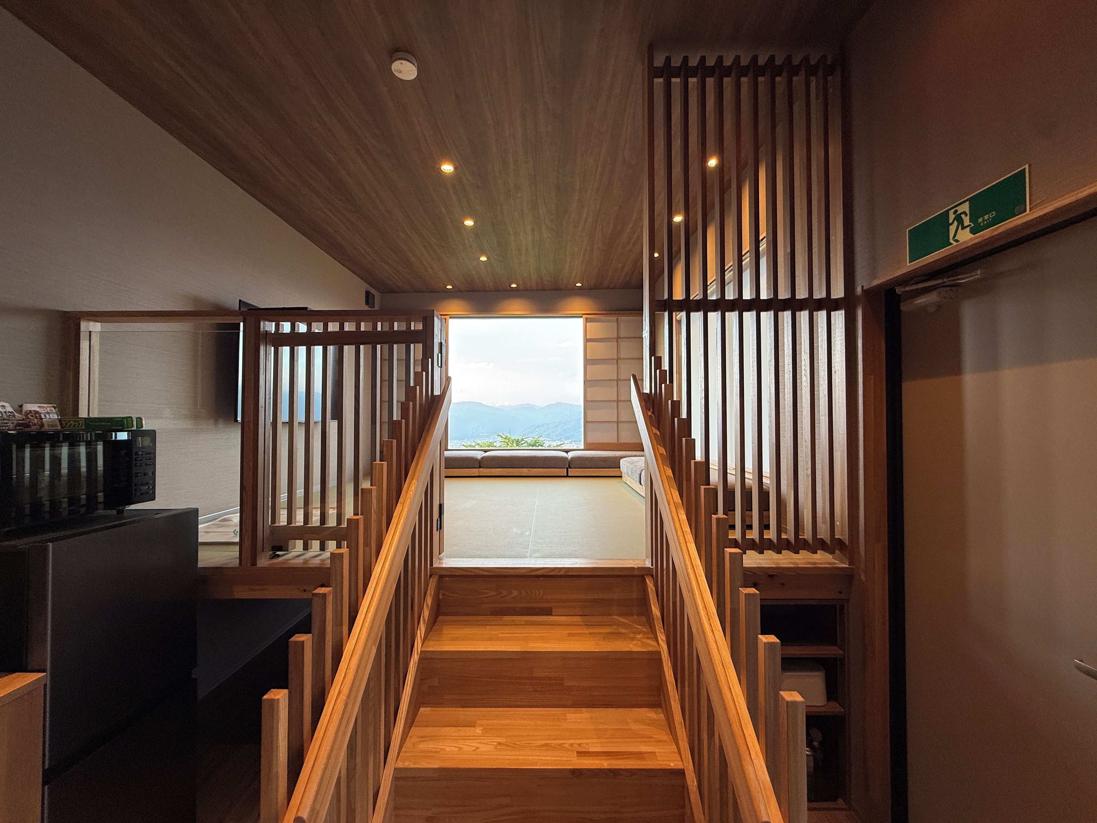 Una escalera de madera que conduce a un balcón con vistas a montañas.